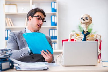 İskeletle çalışan bir iş adamı.