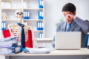 İskeletle çalışan bir iş adamı.