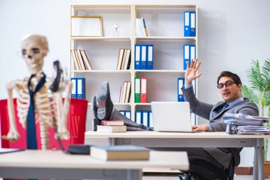 İskeletle çalışan bir iş adamı.