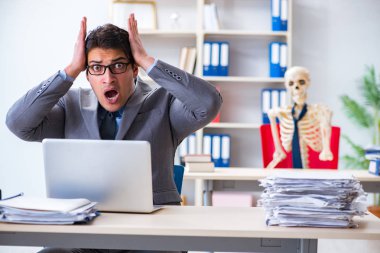 İskeletle çalışan bir iş adamı.