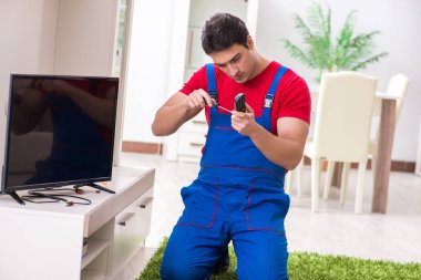 Profesyonel tamir mühendisi bozuk televizyonu tamir ediyor.