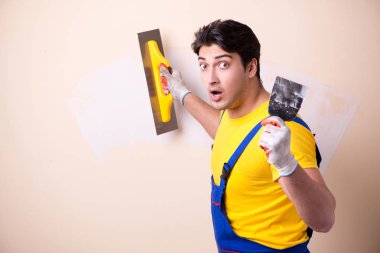 Duvara alçı yapıştıran genç müteahhit.