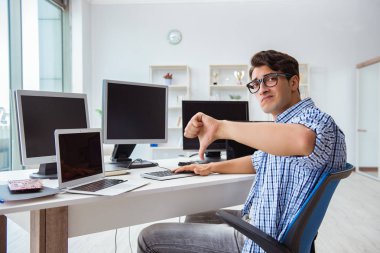 Birçok ekranın önünde oturan bir iş adamı