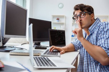 Birçok ekranın önünde oturan bir iş adamı