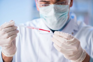 Laboratuvar asistanı hastanede kan örneklerini test ediyor.