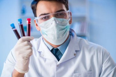 Laboratuvar asistanı hastanede kan örneklerini test ediyor.