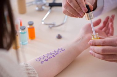 Hastanedeki hastanın alerji reaksiyonunu test eden doktor.