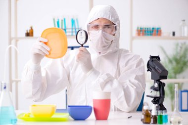 Plastik tabakları kontrol edip test eden kimyager.