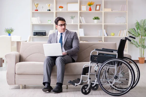 Homme d'affaires en fauteuil roulant travaillant à domicile — Photo