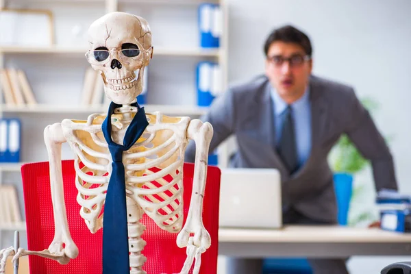 Homme d'affaires travaillant avec squelette dans le bureau — Photo