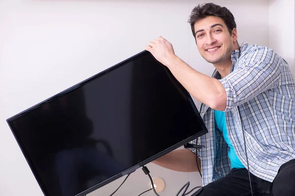 Man repairing broken tv at home