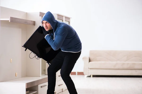 Man burglar stealing tv set from house — Stock Photo, Image
