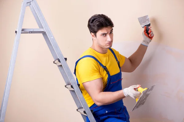 Empregado jovem empreiteiro aplicando gesso na parede — Fotografia de Stock