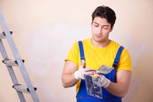 Empregado jovem empreiteiro aplicando gesso na parede — Fotografia de Stock