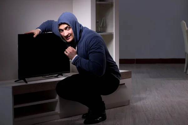 Burglar thief stealing tv from apartment house — Stock Photo, Image