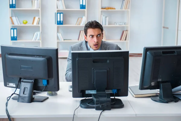 Geschäftsmann sitzt vor vielen Bildschirmen — Stockfoto