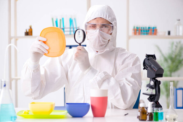 Chemist checking and testing plastic dishes