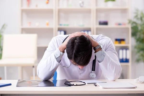 Junger Arzt sitzt im Büro — Stockfoto