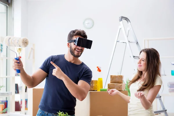 Young family with virtual glasses unpacking at new house with bo