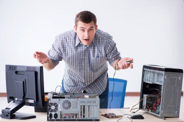 Genç teknisyen atölyede bilgisayar tamir ediyor.