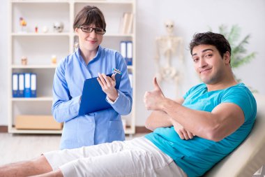 Doktor çekiçle sinir reflekslerini kontrol ediyor