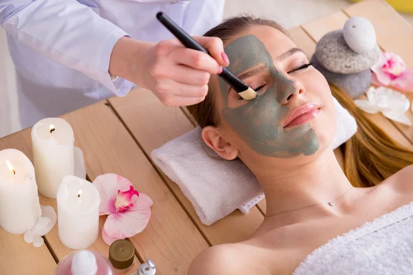 Mujer joven en concepto de salud spa con mascarilla facial — Foto de Stock