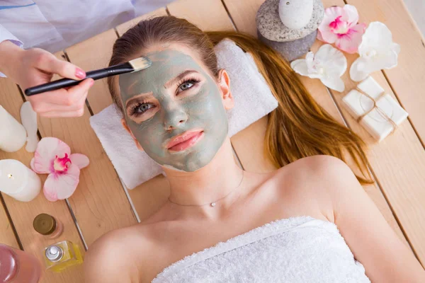 Ung kvinna i spa hälsa koncept med ansiktsmask — Stockfoto