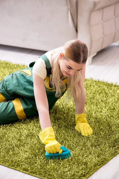 Professional female cleaner cleaning carpet
