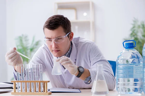 Jeune étudiant chimiste expérimentant en laboratoire — Photo