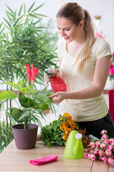 Mujer joven regando plantas en su jardín —  Fotos de Stock