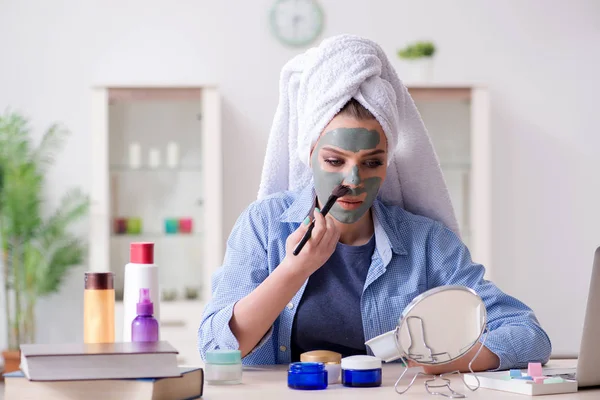 Kadın evde fırçayla kilden maske takıyor