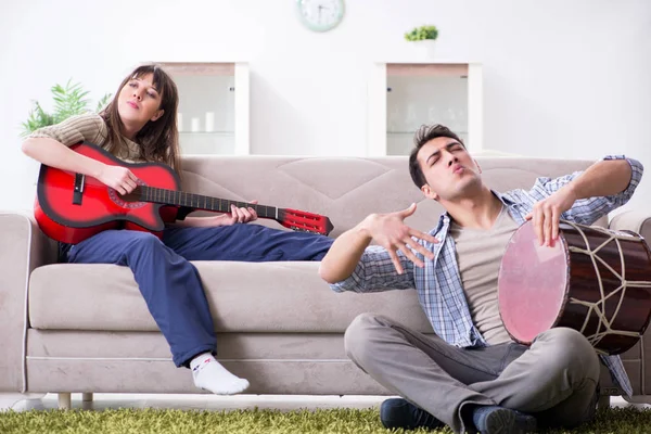 Família jovem cantando e tocando música em casa — Fotografia de Stock