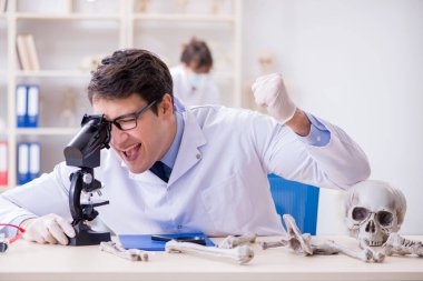 Profesör laboratuvarda insan iskeletini inceliyor.