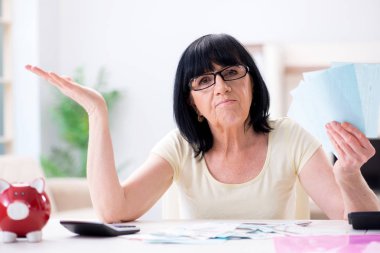 Mature woman trying to reconcile her bills clipart