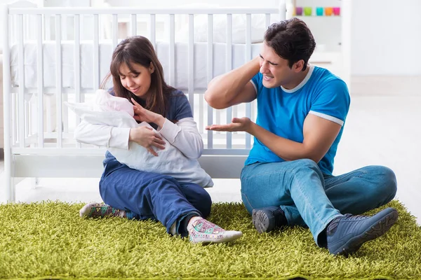 갓 태어난 아기와 함께 카펫 위에 앉아 있는 어린 부모 — 스톡 사진