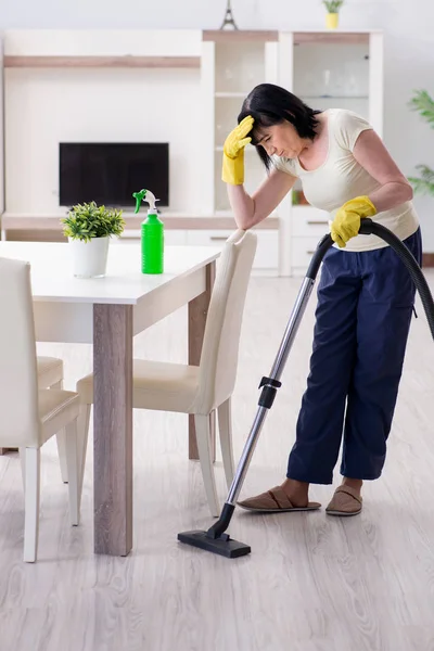 Senior old woman tired after vacuum cleaning house — Stock Photo, Image