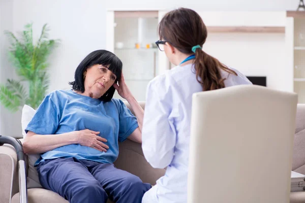 Young doctor visiting old mature woman for check-up — Stock Photo, Image