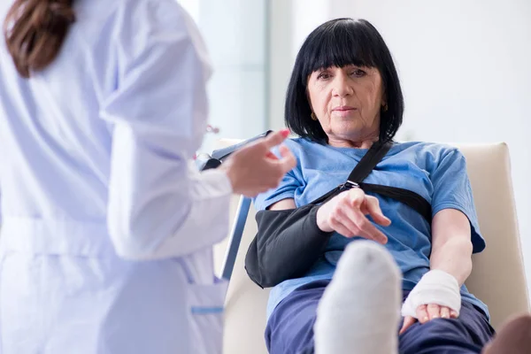 Doktor olaydan sonra yaşlı kadını muayene ediyor. — Stok fotoğraf