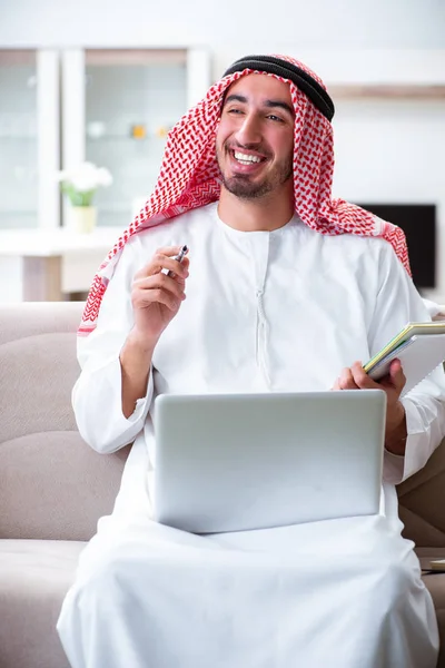 Arap adam evde çalışıyor.