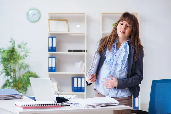 Mujer embarazada luchando para hacer el trabajo en la oficina — Foto de Stock