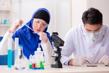 Laboratuvarda çalışan iki kimyager.