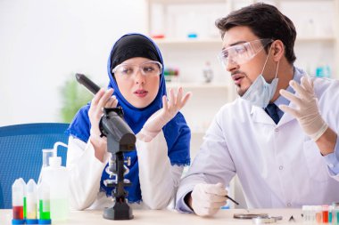 Laboratuvarda çalışan iki kimyager.