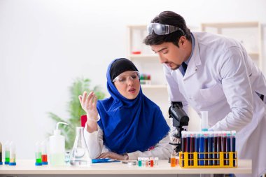 Laboratuvarda çalışan iki kimyager.