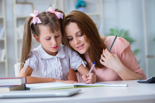 Anne, kızına ödevlerinde yardım ediyor.