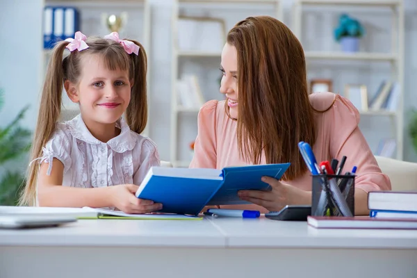 Anne, kızına ödevlerinde yardım ediyor.