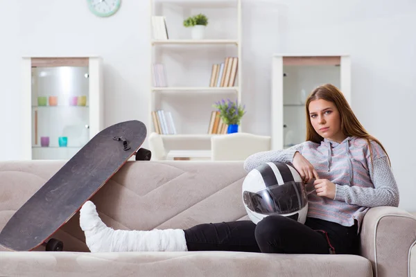 Junge Frau mit gebrochenem Bein zu Hause — Stockfoto