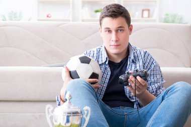 Genç adam evde bilgisayar oyunu oynuyor.