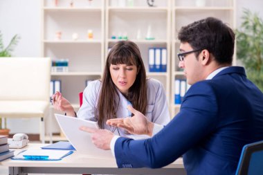 İş adamı doktorla sağlık sorunlarını tartışıyor