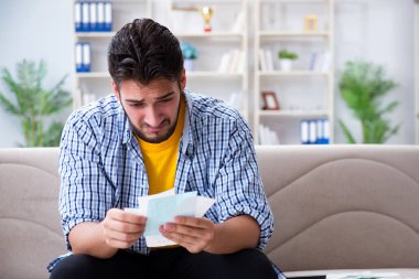 Ödeme yapması gereken faturalara kızgın bir adam.