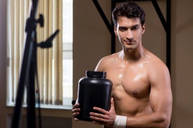 Spor salonunda besin takviyesi olan bir adam.